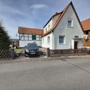 Ein zweistöckiges Haus mit einem Auto auf der Einfahrt.