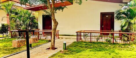 A building with a red roof, a door labeled '1018', and a tree in the foreground.