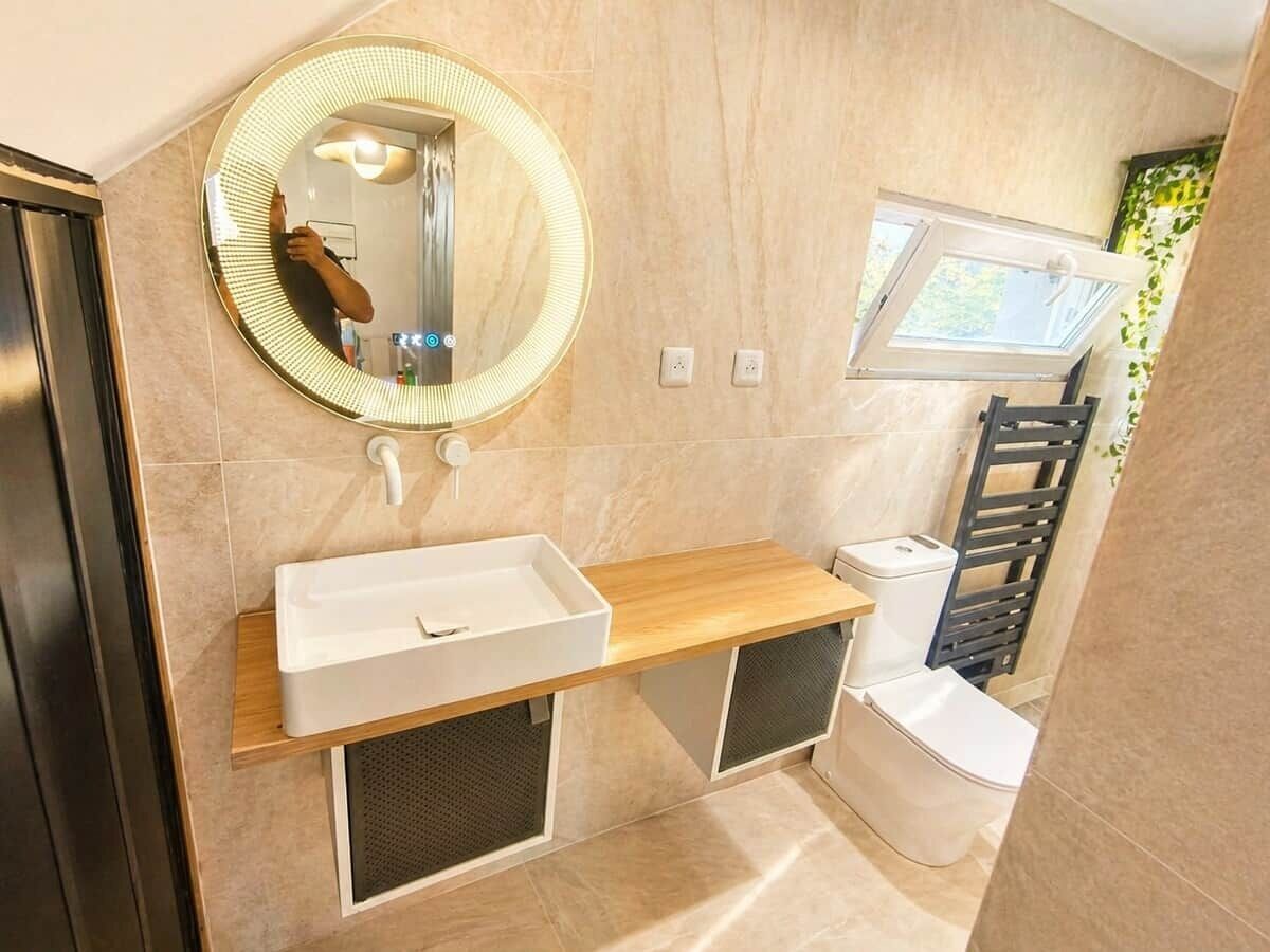 A modern bathroom with a vanity, mirror, and toilet.