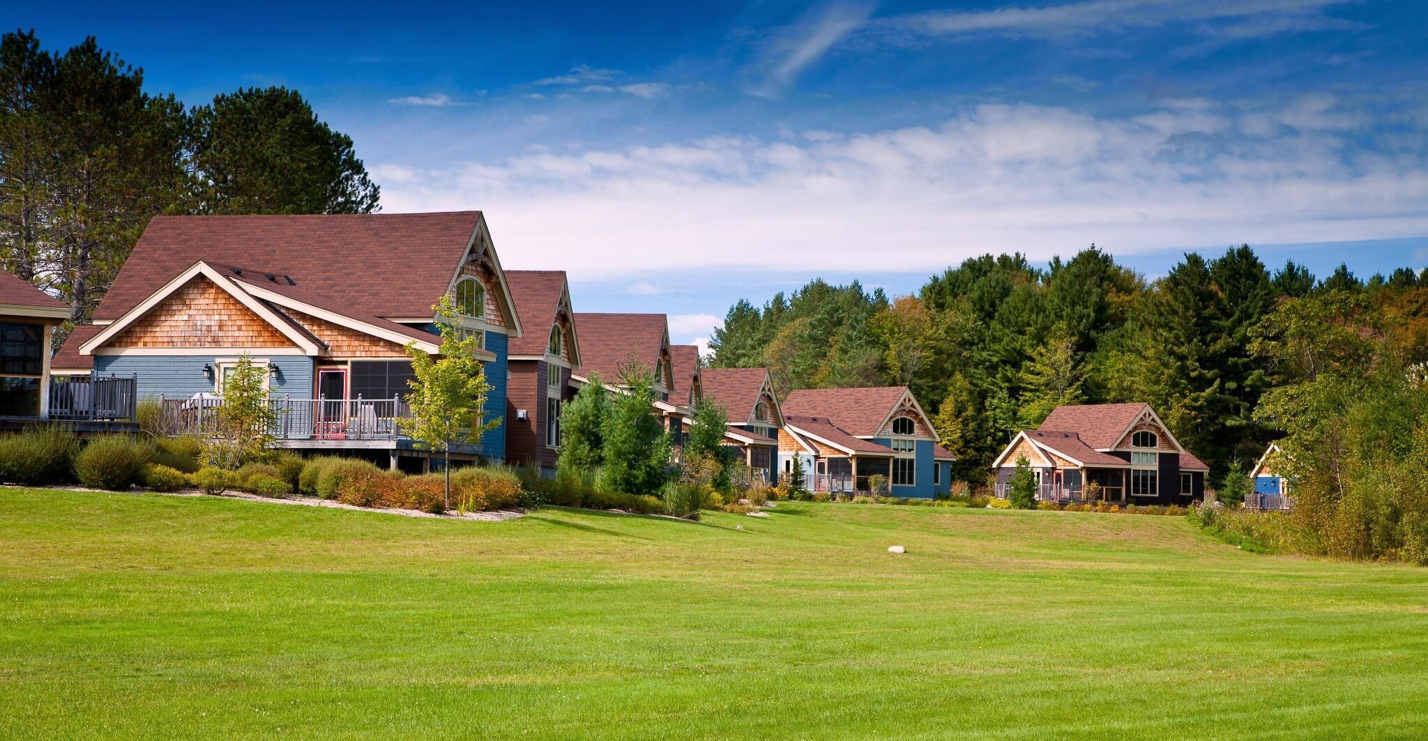 A row of houses with a grassy lawn in front.