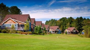 A row of houses with a grassy lawn in front.