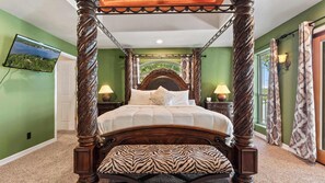 A four-poster bed with a zebra-patterned pillow, a nightstand with a lamp, and a view of a landscape through a window. - Riviera Paradise Lake Luxury (Sunrise Beach)