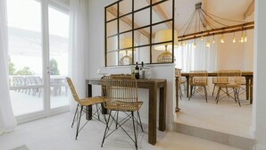 A room with a large window, a dining table with chairs, and a chandelier. - Historic villa with private pool near Florence (Vinci)