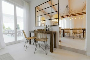 A room with a large window, a dining table with chairs, and a chandelier. - Historic villa with private pool near Florence (Vinci)