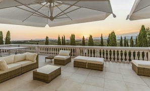 A terrace with outdoor furniture, a table, and a view of the landscape. - Historic villa with private pool near Florence (Vinci)