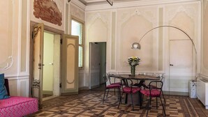 Un comedor con una mesa, sillas y un jarrón de flores.