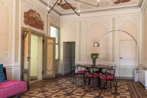 A dining area with a table, chairs, and a vase of flowers. - Attilia Suite Historical House in Chioggia canal view Vena Laguna di Venezia (Chioggia)