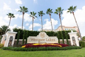 Schild für Westgate Lakes Resort & Spa, umgeben von Palmen und einem gepflegten Garten.