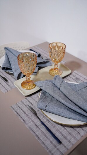 A table set with two glassware items, a folded napkin, and a placemat.