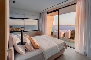 A modern bedroom with a large bed, a view of the sea, and a balcony. - Syvana Exquisite Villas III (Syvota)