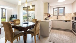 Una cocina moderna con comedor, ventanas amplias y vistas a edificios.