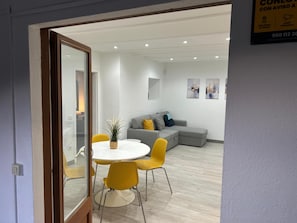 A modern living room with a grey sofa, yellow chairs, and a white table. - Cal Botey Apartment with Mountain Views, Wi-Fi, and Air Conditioning (Ripoll)