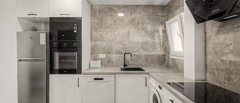 Cocina moderna con electrodomésticos integrados, lavavajillas y microondas.