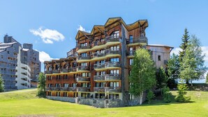 Ein mehrstöckiges Hotel mit Balkonen, einem Steinfundament und blauem Himmel.