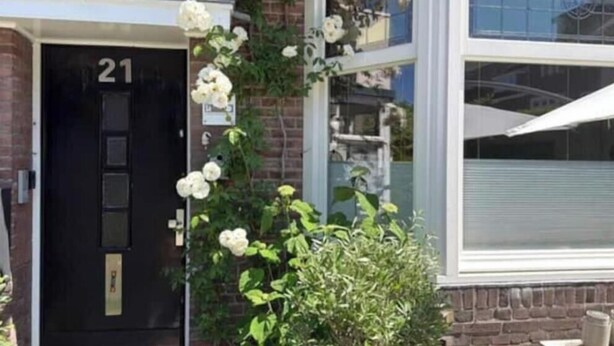 A building with a black door marked '21', a brick facade, and a window with a white awning. - Attractive years-30s dream house Center Maastricht / district St.. Pieter (Maastricht)