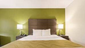 Ein Hotelzimmer mit einem Bett, zwei Nachttischen und einem Kopfteil.