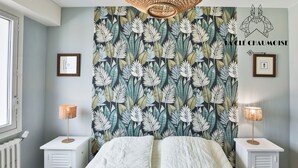 A bedroom with a bed, two bedside tables, a wall tapestry, and a window. - Brasilia - Vue mer d’exception aux Sables, balcon & plage (Les Sables-d´Olonne)