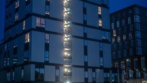 Un hôtel à plusieurs étages doté d’un atrium central, de grandes fenêtres et d’une architecture moderne.