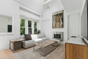 Ein modernes Wohnzimmer mit einer Couch, einem Couchtisch, einem Fernseher und Kunstwerken.