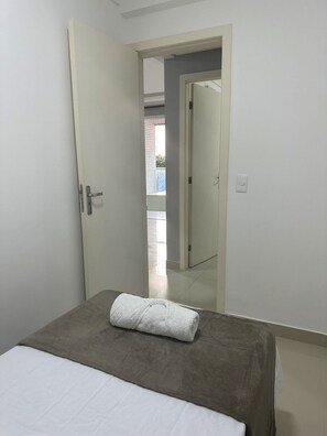 A bedroom with a bed, a door, and a view of an outdoor balcony. - 3 bedrooms with the best location in Guarapari (Guarapri)