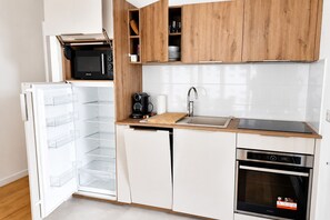 A compact kitchen with a built-in microwave, a coffee maker, a sink, and a dishwasher. - Modern & Smart Paris 13 Bibliothèque François Mitterrand (Paris)