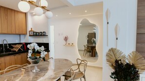Uma cozinha moderna com armários de madeira, uma mesa de jantar de mármore e um candelabro.