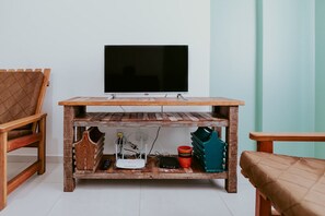 Ein Fernsehschrank aus Holz mit einem Flachbildfernseher, einem Router und einer roten Tasse.