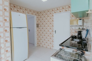Eine Küche mit Kühlschrank, Mikrowelle, Kaffeemaschine und Gasherd.
