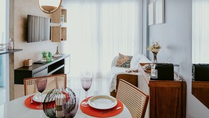 Een moderne hotelkamer met een zithoek, een aan de muur bevestigde televisie en een bed met uitzicht.