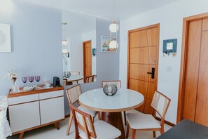 Ein Essbereich mit einem runden Tisch, Stühlen, einem Schrank und einer Hängelampe.