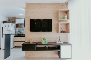 Eine moderne Küche mit integriertem Fernseher, Holzschränken und einem minimalistischen Design.