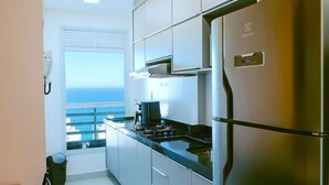 A modern kitchen with stainless steel appliances, a view of the ocean, and a balcony. - Modern apartment with incredible sea views (Vila Velha)