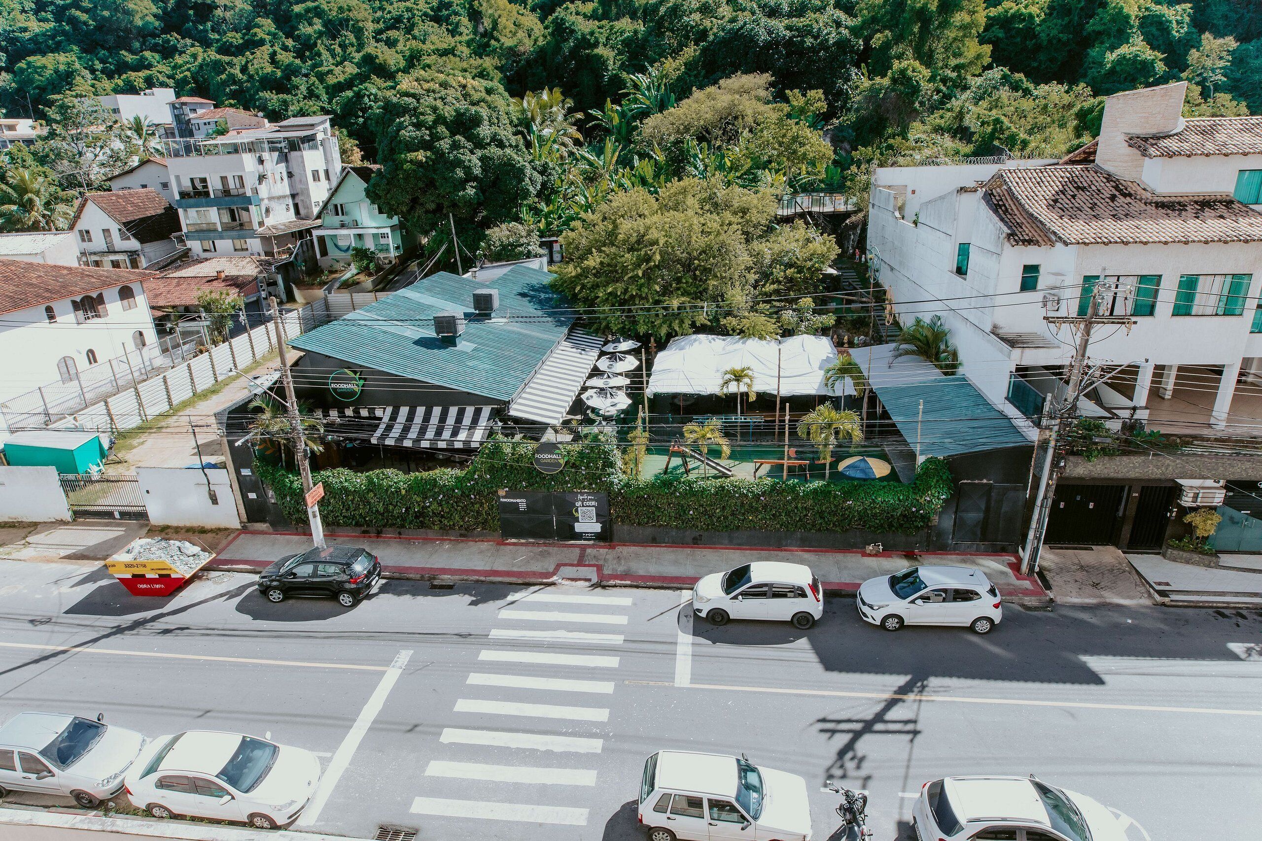 An aerial view of a residential area with buildings, a crosswalk, and parked cars.