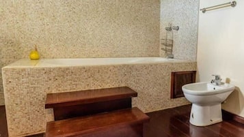 Separate bathtub and shower, towels, soap, toilet paper