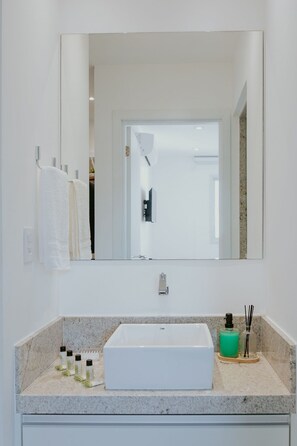 A bathroom with a white sink, mirror, and towel rack. - Modern 2-bedroom apartment with pool and gym. (Vila Velha)