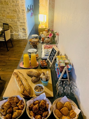 Un buffet de petit-déjeuner comprenant du pain, des viennoiseries et des boissons.