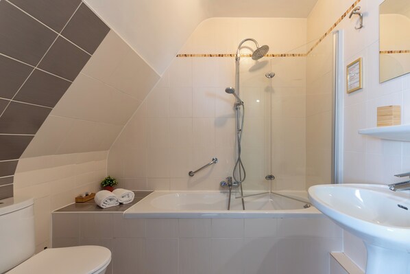 Un baño moderno con bañera, ducha y lavamanos.