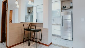 Cocina moderna con isla integrada, electrodomésticos de acero inoxidable e iluminación colgante.