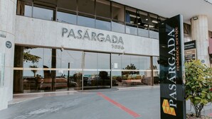 Ein Gebäude mit einem großen Schild, auf dem 'PASARGADA 1856' steht, und einem kleineren Schild darunter, das 'PASARGADA residence service' anzeigt.