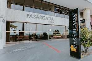 Ein Gebäude mit einem großen Schild, auf dem 'PASARGADA 1856' steht, und einem kleineren Schild darunter, das 'PASARGADA residence service' anzeigt.