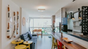 Eine moderne Küche mit Bar, Esstisch und einer Couch.