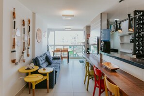 Une cuisine moderne avec un coin bar, une table à manger et un canapé.