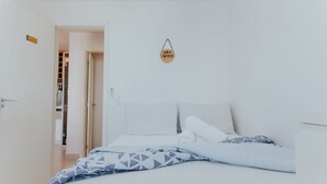 Ein Schlafzimmer mit einem Bett, Kissen, einem hängenden Schild und einem Schrank.
