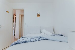 Une chambre à coucher avec un lit, des oreillers, une enseigne suspendue et un placard.