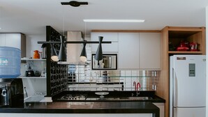 Eine moderne Küche mit schwarzem Arbeitsplatz, Edelstahlgeräten und Holzausstattung.