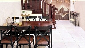 Ein Essbereich mit Holztisch und -stühlen, einer Treppe und einem Deckenventilator.