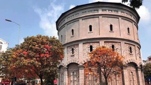 Ein historisches Gebäude mit einer runden Struktur, Bogenfenstern und Steinmauern.
