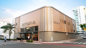 En modern byggnad med en böjd fasad, där namnet ”extroplus” är tydligt synligt, och ett övergångsställe framför.