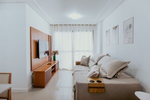 Ein modernes Wohnzimmer mit einer Couch, einem Fernseher und Kunstwerken an der Wand.