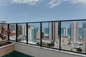 Um edifício alto com vista para o oceano e outros edifícios.